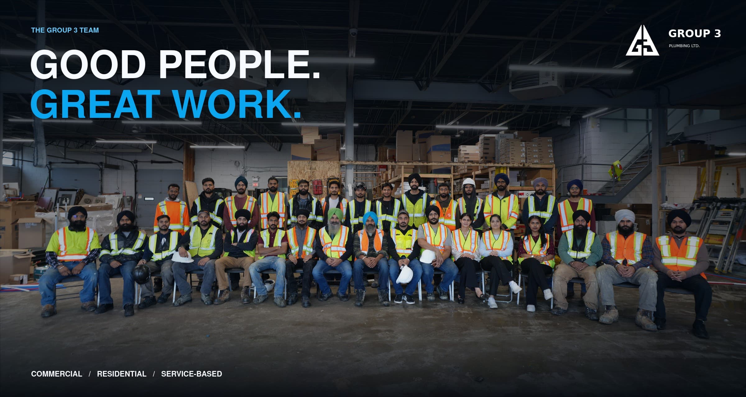 The full Group 3 Plumbing crew, about thirty people in high-visibility vests, seated and standing in two rows in the shop, under the words: The Group 3 team. Good people. Great work. Commercial, residential, service-based.